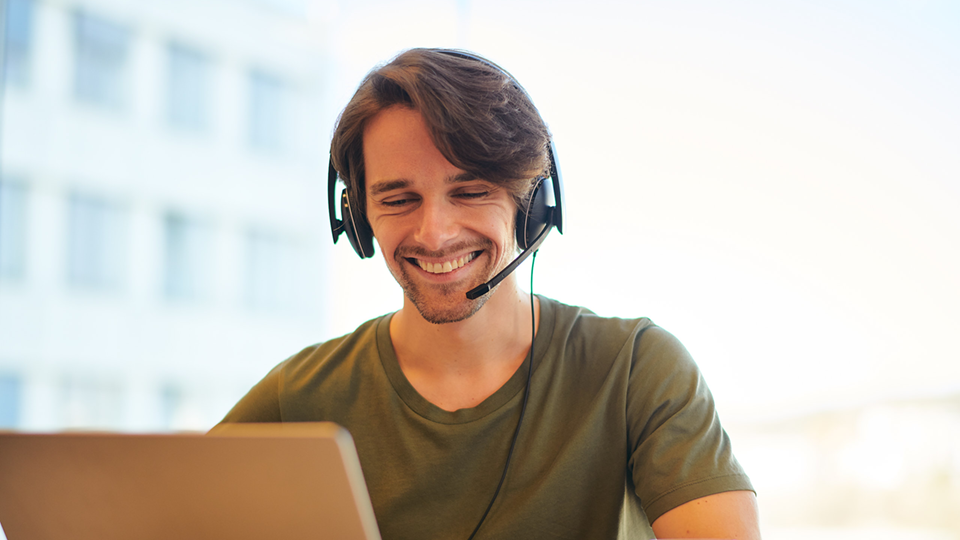 Junger Mann mit Headset am Computer
