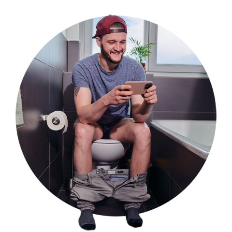 Mann im blauen T-Shirt schaut fröhlich auf der Toilette am Smartphone fern
